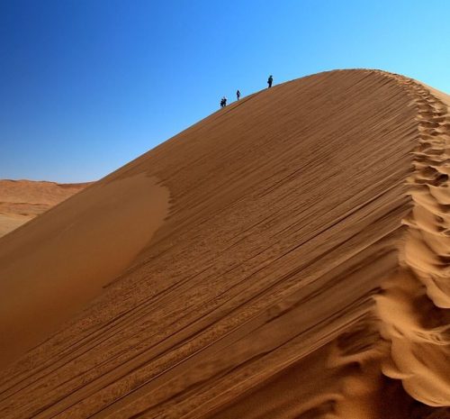 Viajeros caminando por las dunas de Sossusvlei durante un itinerario de 7 días por Namibia